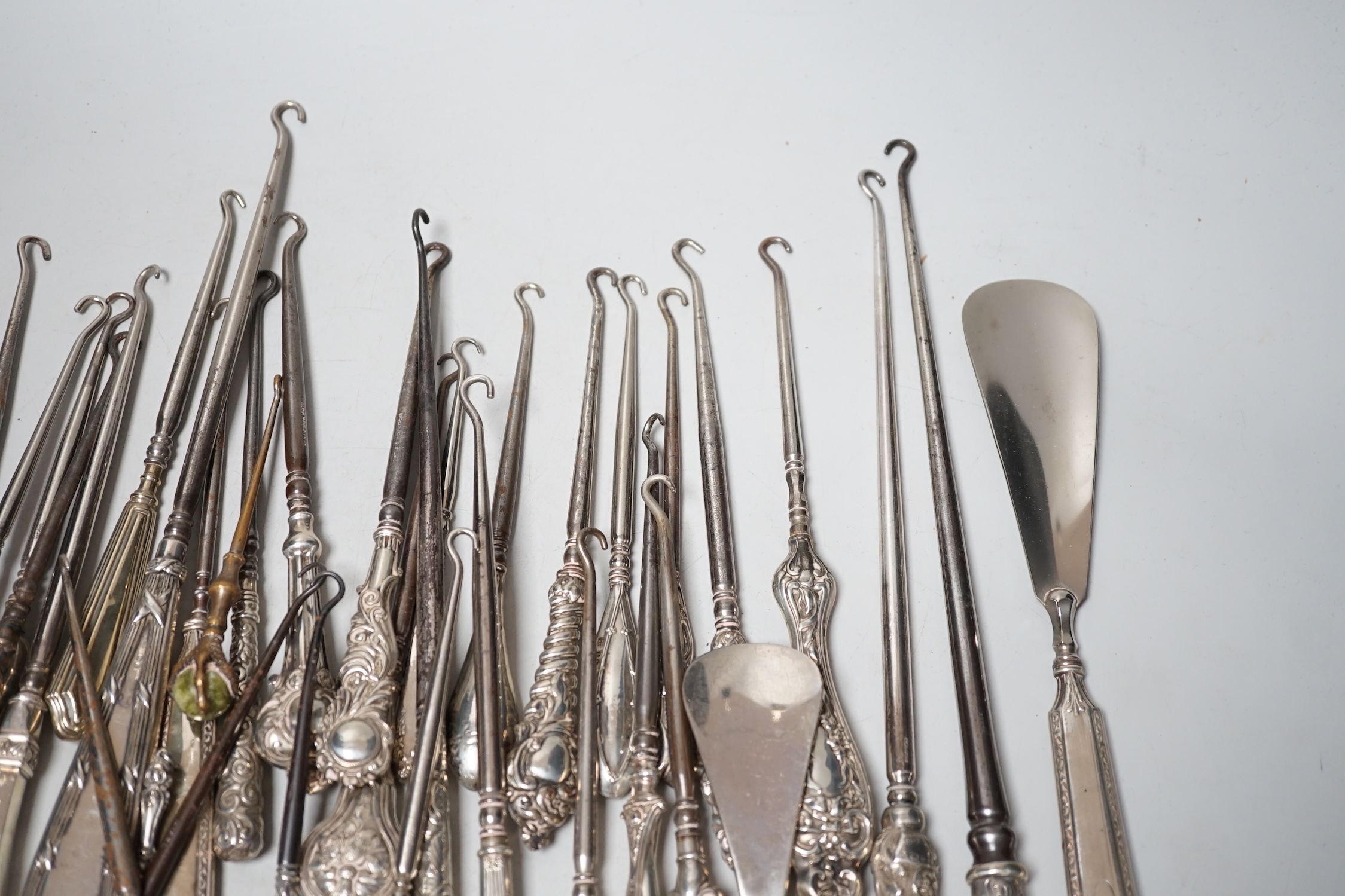 A large collection of mainly silver handled button hooks and two shoe horns.